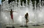 Børn leger i springvandet i byen Antibes i det sydlige Frankrig. Det formodes, at ni mennesker er døde i Frankrig under sommerens hedebølge. - Foto: AP 