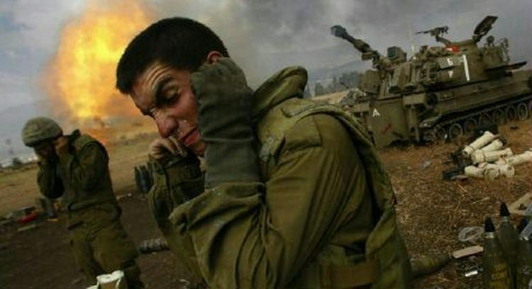 Israelske soldater holder sig for ørene, mens de affyrer granater mod Sydlibanon. - Foto: AP 