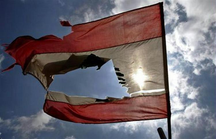 Et sønderskudt libanesisk flag nær grænsen til Israel. - Foto: AP 