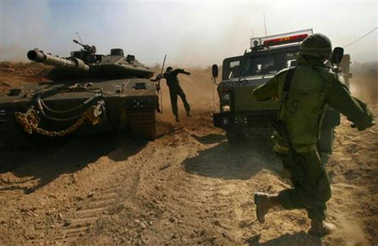 En israelsk soldat hopper ned fra en kampvogn for at hente sårede under kampe i det sydlige Libanon. - Foto: AP 
