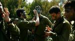 Israelske soldater lægger camouflage, inden de skal krydse grænsen til Libanon. Kampene om Bint Jbeil i det sydlige Libanon har kostet Israel store tab. - Foto: AP 