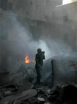 Et af målene i går for de israelske kampfly var centrum af den libanesiske kystby Tyre, hvor en mand i minutterne efter fuldtræfferne, prøvede at beskytte sig imod røgen, mens kan prøvede at få et overblik over ødelæggelserne.   Foto: AP 