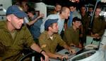 Israels premierminister Ehud Olmert ser på en monitor under et besøg i dag på et israelsk flådefartøj. Premierministeren mener, en våbenhvile er på vej. - Foto: AP 