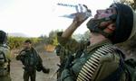 En israelsk soldat drikker vand, efter at være vendt tilbage over grænsen til Libanon - Foto: AP 