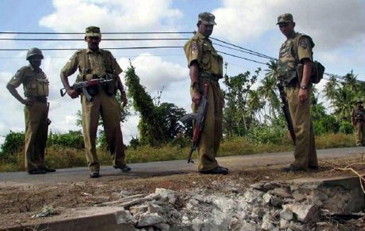 Srilankanske regeringssoldater ser på nedslagsstedet for en granat, som de tamilske oprørere fredag sendte efter en konvoj med soldater. - Foto: AP 
