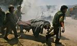 Israelske soldater bærer et offer væk for Hizbollahs raketangreb i dag på Kfar Giladi i Israel, hvor mindst ti mennesker blev dræbt. - Foto: AP 