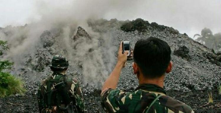 En soldat tager et billede af lavaen fra vulkanen Mayon. - Foto: AP 