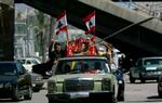 Libanesere i Beiruts gader fejrer våbenhvilen med at prise Hizbollahs leder Hassan Nasrallah og Irans præsident Mahmoud Ahmedinejad. - Foto: AP 