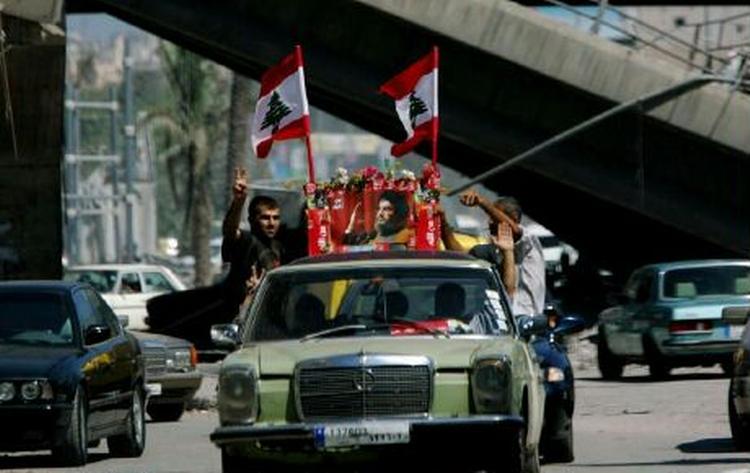 Libanesere i Beiruts gader fejrer våbenhvilen med at prise Hizbollahs leder Hassan Nasrallah og Irans præsident Mahmoud Ahmedinejad. - Foto: AP 