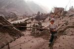 En dreng børster vulkansk aske af et hustag i Banos, Ecuador. - Foto: AP 