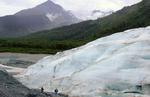 To personer passerer en gletscher i Alaska. Det viser sig, at gletscherne over lang tid har trukket sig langsomt tilbage. - Arkivfoto: AP 