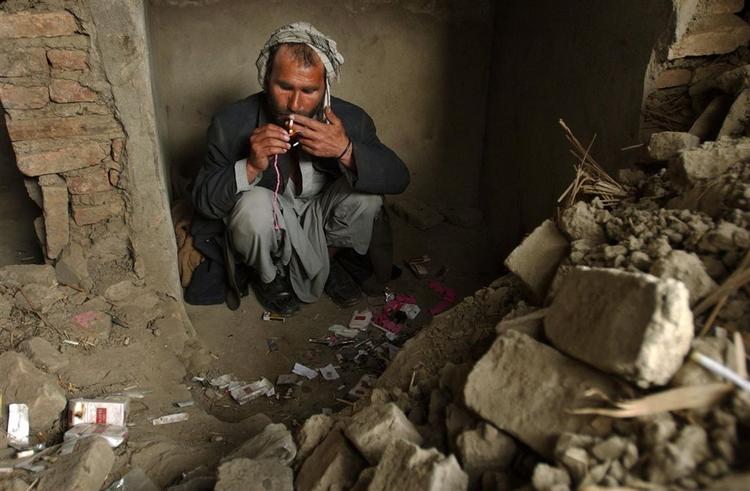 En afghansk opiumsmisbruger ryger en cigaret. Produktionen af opium er stærkt stigende. 