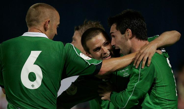 Holdkammeraterne omfavner dagens mand i skysovs, David Healy. 