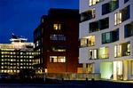 Ruth Campaus glasskillere med silketrykte striber følger farvelæren og kaster klædelige skygger på den hvide arkitektur. 