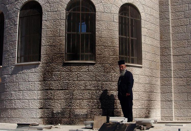Græsk-ortodokse præst, George Awad, besigtiger brandskaderne på sin kirke i Nablus på Vestbredden i går. 
