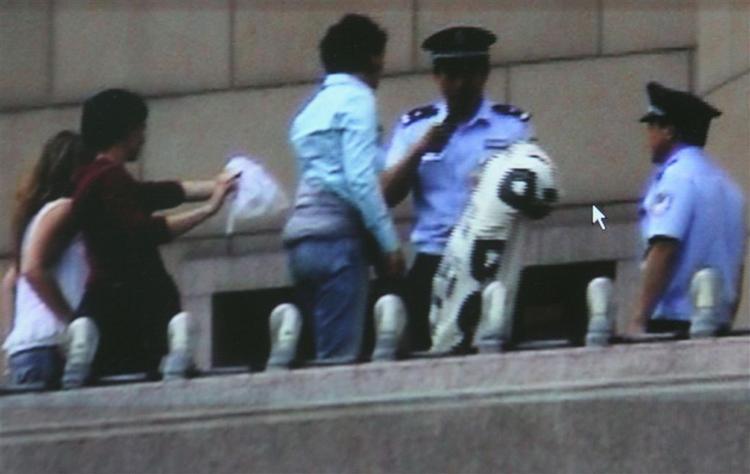 Modstandere af Kinas Tibet-politik bliver anholdt i Beijing. Censur er et af de brud på menneskerettighederne, som Kina anklages for i en ny rapport. 