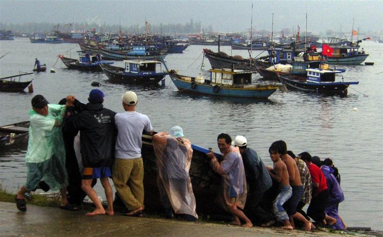 Vietnamesiske fiskere hiver deres både på land inden tyfonen Xangsane rammer kysten. 