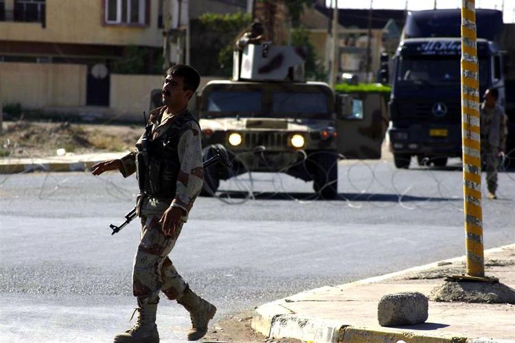 En irakisk soldat går gennem forladte gader i Kirkuk under udgangsforbuddet. 