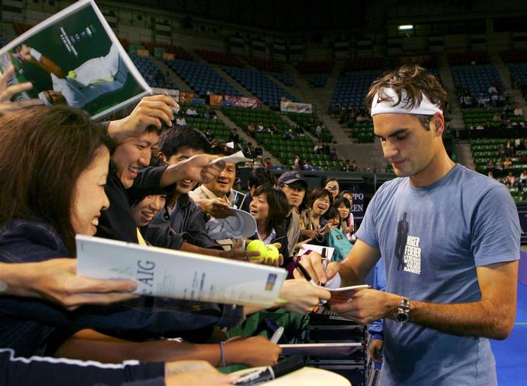 Roger Federer skriver autografer til japanske fans efter sin niende titel i år. 