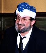 For 10 år siden – i november 1996 – var den fatwa-truede forfatter Salman Rushdie på besøg i Danmark for at modtage EU’s litteraturpris under store sikkerhedsforanstaltninger – dog ikke større, end at han bagefter kunne tage ud i nattelivet. Så da Tuborgs ølbil rullede op foran det lille Frederiksberg-værtshus Promenaden, kunne de lårkorte nissepiger overdrage en af nissehuerne med blåt blink til den verdensberømte forfatter. Foto: Brian Møller/Ekstrabladet 