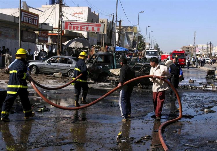 Irakiske brandfolk rydder op efter en eksplosion i Bagdad. 