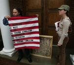 William Gentry - til venstre - fremviser et amerikansk flag og bag ved det, på jorden, et friturestegt flag, begge fra udstillingen. 