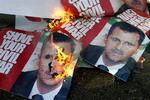 Sørgende afbrænder bannere af Syriens præsident Bashar Assad forud for b egravelsen af den myrdede Pierre Gemayel. 