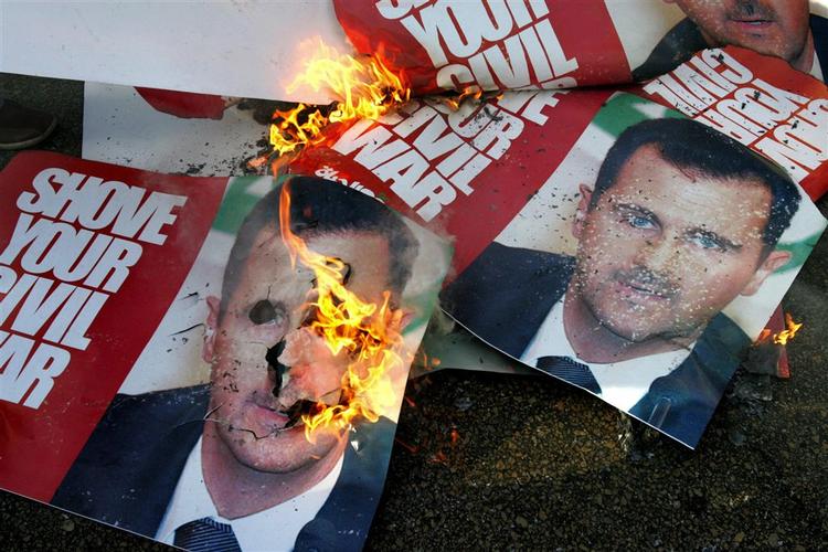 Sørgende afbrænder bannere af Syriens præsident Bashar Assad forud for b egravelsen af den myrdede Pierre Gemayel. 