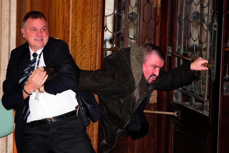 En af sikkerhedsfolkene holder fast i den mand, der kastede en bombelignende pakke mod det nordirske parlament - den berygtede Michael Stone. 