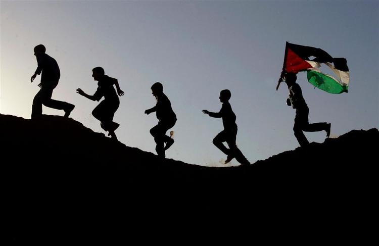 Palæstinensiske unge indtager bakkerne omkring Beit Lahiya i det nordlige Gaza, efter israelske tropper har trukket sig ud af området. 