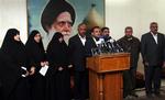 En flok af al-Sadr-støtter lyttede, mens Salih al-Igeili (midt for) læste deres protesterklæringen op.Plaketen bagved forestiller Mohammed Sadiq al-Sadr, Muqtada al-Sadr's afdøde far. 