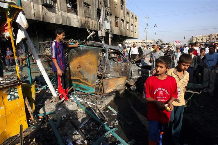 Indbyggere i Bagdad går forbi skaderne efter en bilbombe i et hovedsageligt shiamuslimske område Shaab i Bagdad i oktober, 2006. 10 blev dræbt og 23 såret. 
