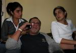 Hector Palacios (i midten) taler i telefon, mens hans datter, Gisel Recaren (t.v.) og hans kone Gisela Delgado sidder omkring ham i huset i Havana. 