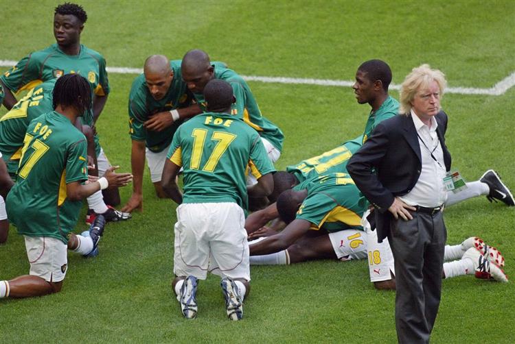 Camerouns fodboldspillere og deres tyske træner Winfried Schaefer er samlet på grønsværen, før Confederations Cup finalen mod Tyskland, 29. juni 2003. Camerouns spillere bærer alle trøjer med navnet "Foe" til minde om Camerouns midtbanespiller Marc-Vivien Foe, som døde nogle dage forinden af en hjertefejl under Camerouns semifinale-kamp mod Colombia. 