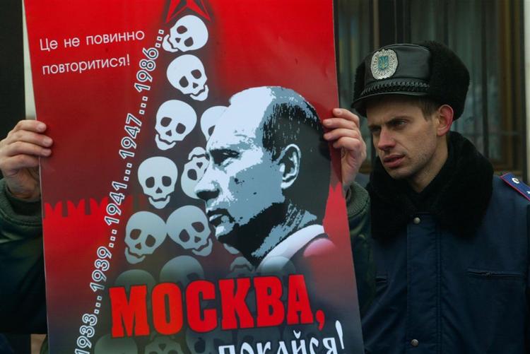 En ukrainsk nationalist holder en anti-Putin plakat op foran den russiske ambassade i Kiev i Ukraine. 