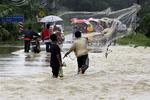 Malaysia er blandt de værst ramte lande. Her fisker en mand midt på en oversvømmet vej. 