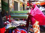 En kvinde køber tøj i Mogadishu forud for en muslimsk helligdag søndag. De islamistiske oprørere forlod torsdag hovedstaden. 