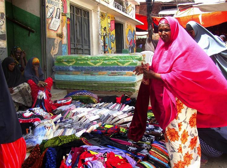 En kvinde køber tøj i Mogadishu forud for en muslimsk helligdag søndag. De islamistiske oprørere forlod torsdag hovedstaden. 