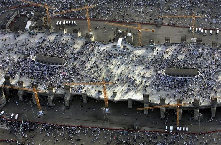 To dage i træk skal pilgrimme, der samles under eller på Jamarat-broen, ramme tre søjler med hver syv sten, i ritualet »steningen af djævelen«. Billedet er fra den 31. december, hvor i alt tre millioner mennesker kastede hver deres 21 sten, plus dem der ikke ramte. To af søjlerne er synlige midt på broen. 