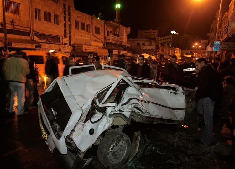 Palæstinensere samlet omkring en bil, der blev ødelagt under de israelske kampvognes indtrængen i Ramallah. 