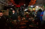 Palæstinensere står ved en række frugtboder, der er ødelag efter den israelske aktion i Ramallah. 
