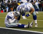 Dallas Cowboys quarterback Tony Romo tager sig til hovedet efter sin brøler, der kostede sejren mod Seattle Seahawks. Over ham står Al Johnson, som enten trøster ham, eller skælder sin holdkammerat hjelmen fuld. 