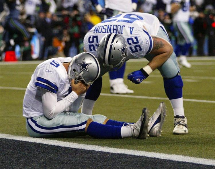 Dallas Cowboys quarterback Tony Romo tager sig til hovedet efter sin brøler, der kostede sejren mod Seattle Seahawks. Over ham står Al Johnson, som enten trøster ham, eller skælder sin holdkammerat hjelmen fuld. 