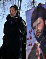 En dukke-kopi af Saddam Hussein 'hænges' ved siden af billede af den shiamuslimske præst Muqtada al-Sadr i Basra. 