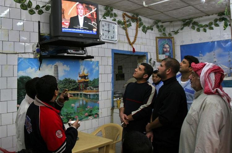 Irakere i Basra følger transmissionen af den amerikanske præsidents tale på en af de nationale tv-kanaler. 