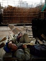 SNORK. Kina har en uregistreret arbejdsstyrke på omkring 140 millioner mennesker, som må sove i den skyskraber, de tilfældigvis er i gang med at bygge. Her er det bygningsarbejdere ved det olympiske stadion, der tager sig en skraber. Foto: Jacob Ehrbahn 