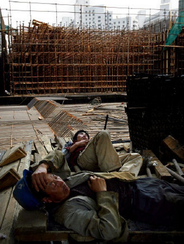 SNORK. Kina har en uregistreret arbejdsstyrke på omkring 140 millioner mennesker, som må sove i den skyskraber, de tilfældigvis er i gang med at bygge. Her er det bygningsarbejdere ved det olympiske stadion, der tager sig en skraber. Foto: Jacob Ehrbahn 