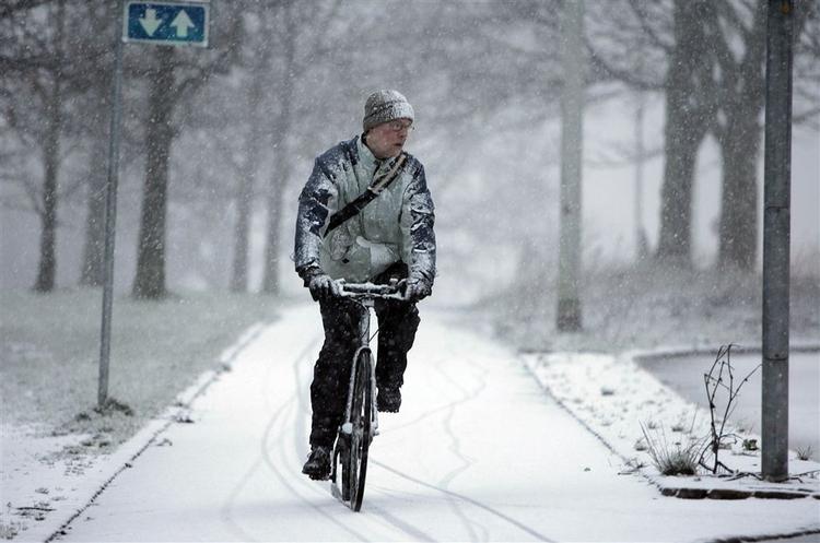 En cyklist kæmper sig vej gennem sneen her til morgen ved søerne i København. 