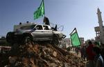 Palæstinensere samles om en bil i Gaza tilhørende Hamas militsfolk. Bilen blev beskudt under fredagens kampe, hvor mindst 12 personer blev dræbt. 