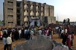 Folk samler sig om den sammenfaldne skole i byen Tichakpura i den indiske Gujarat-provins. Mindst 11 piger er dræbt ved ulykken. 